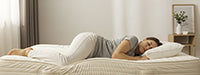 Person lying on a bed with a pillow in a bedroom setting