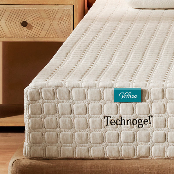 Beige mattress with Technogel branding on a wooden bed frame.