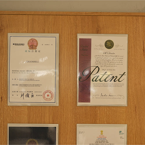 Certificates and patents displayed on a wooden wall
