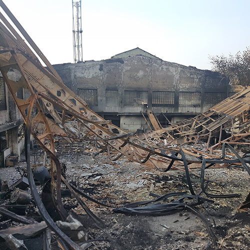 Damaged building with collapsed structures and debris on a clear day