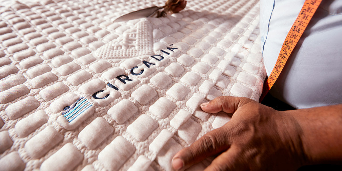 Close-up of a mattress with 'Circadia' branding, showing a hand touching the surface.