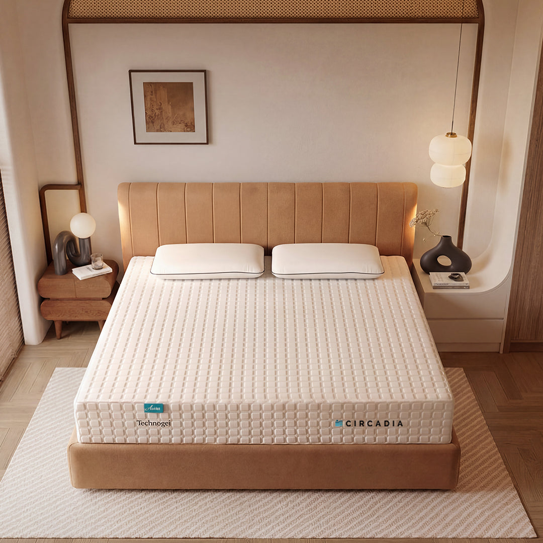 Bed with a white mattress and beige headboard in a bedroom setting.