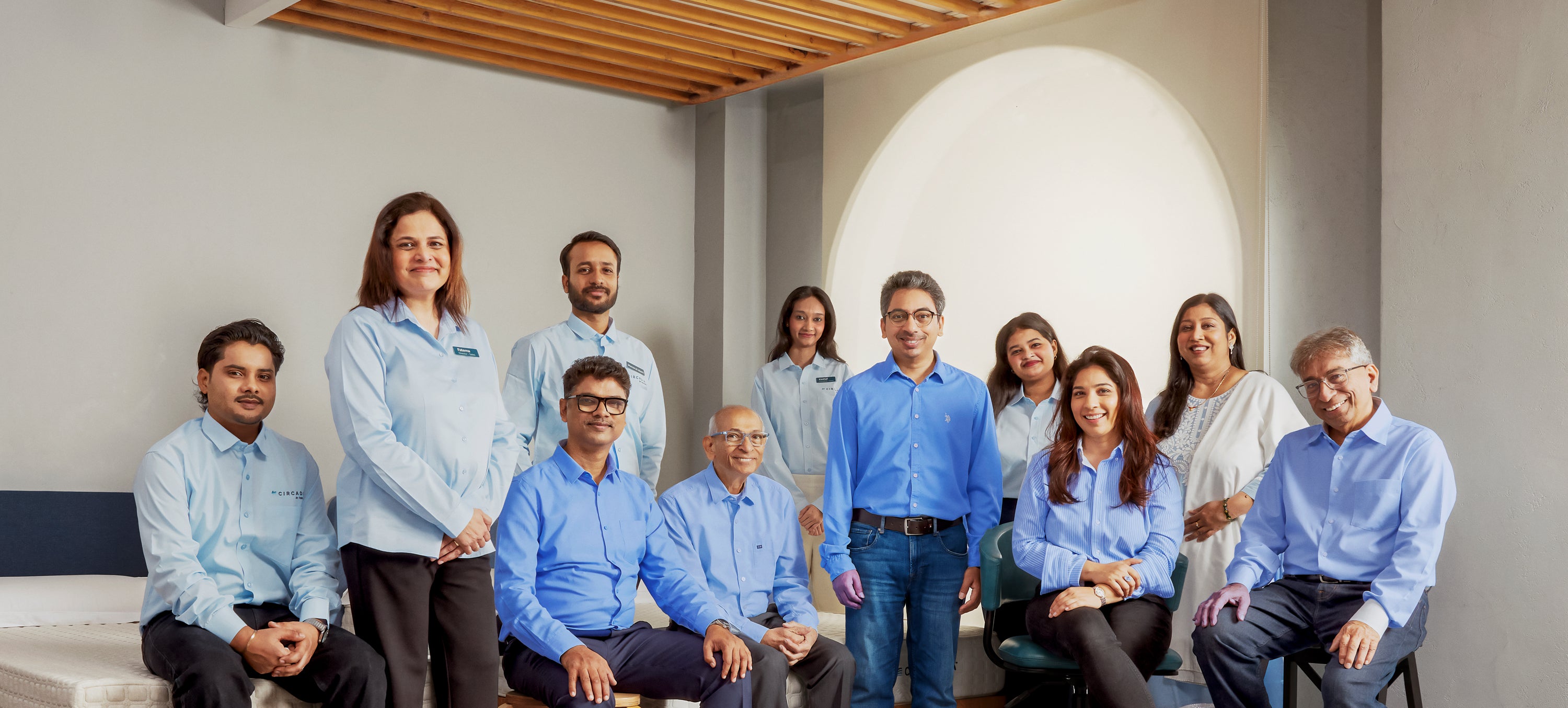 Group of people in blue shirts posing for a photo in an indoor setting.