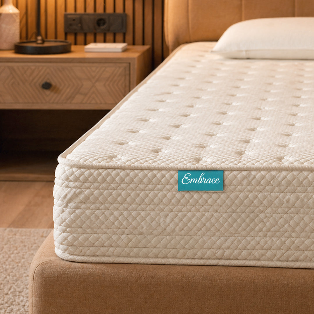 Mattress with 'Embrace' brand logo on a bed in a bedroom setting