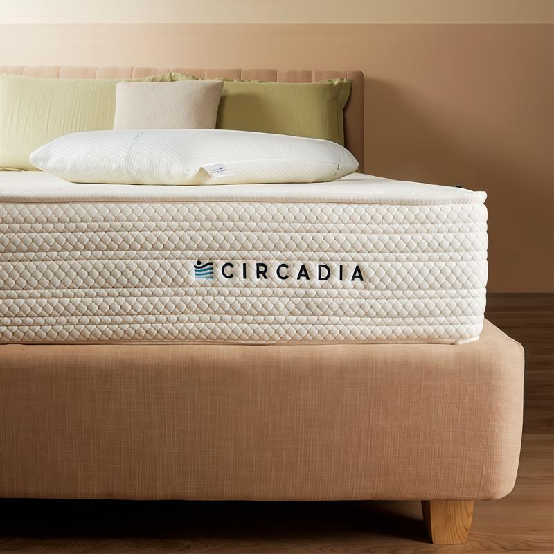 Circadia mattress on a bed with pillows against a beige wall.