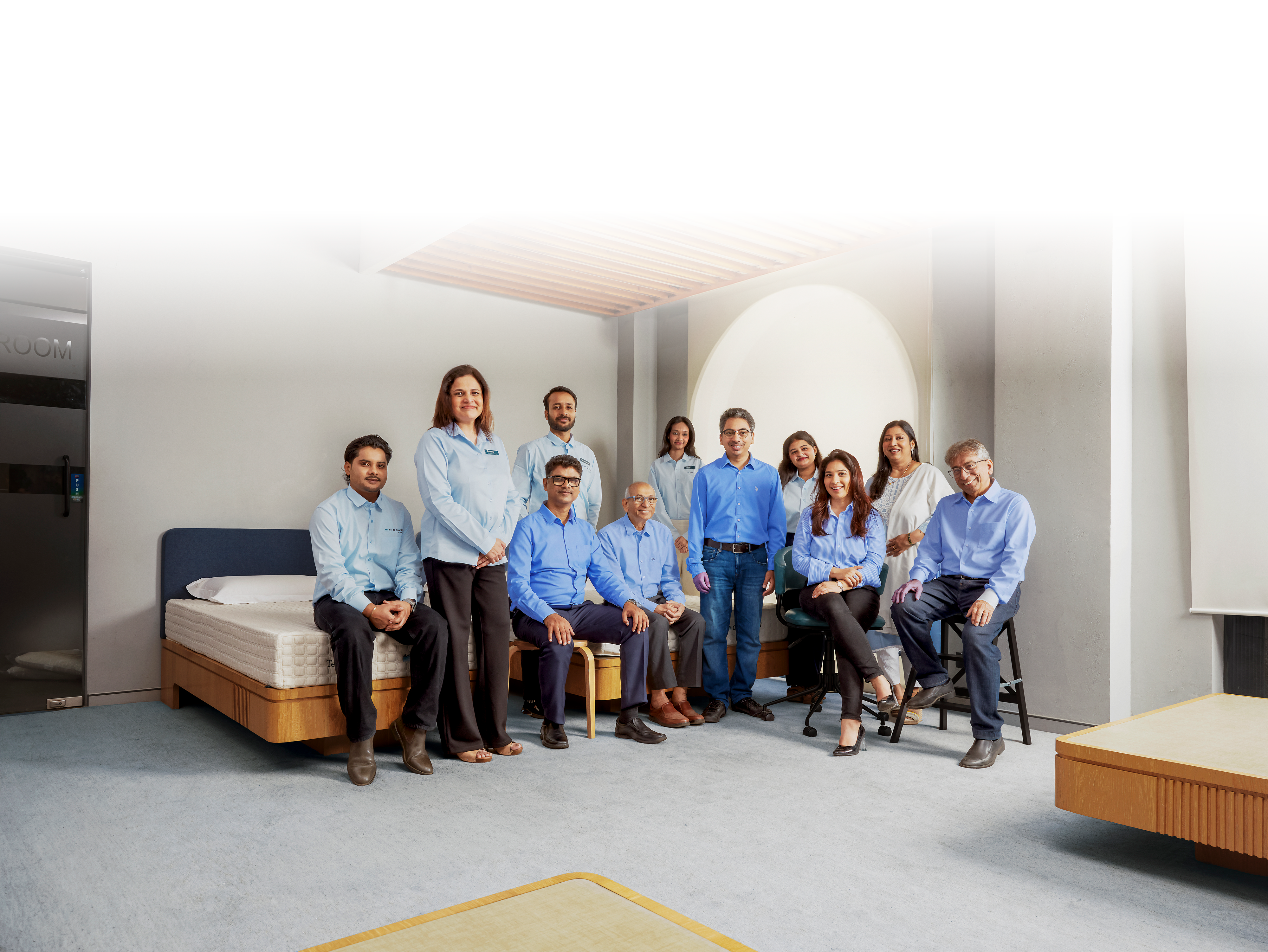 Group of people sitting on a bed in a minimalistic room