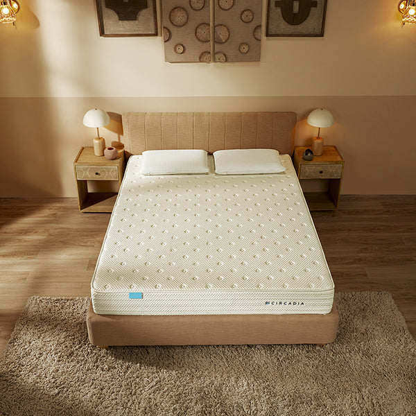 Mattress on a bed in a bedroom setting with bedside tables and lamps.