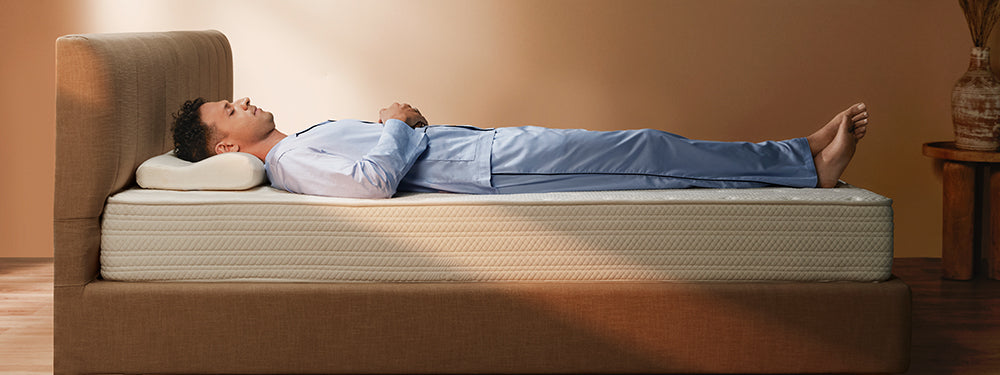 Man lying on a mattress in a room with a neutral color scheme