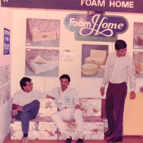 Vintage advertisement for Foam Home mattresses with people sitting on mattresses and a person standing.