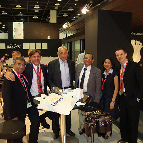 Group of people posing together at a Latexco event with branded items.
