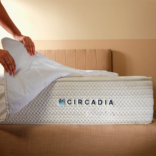 Circadia mattress topper being placed on a bed